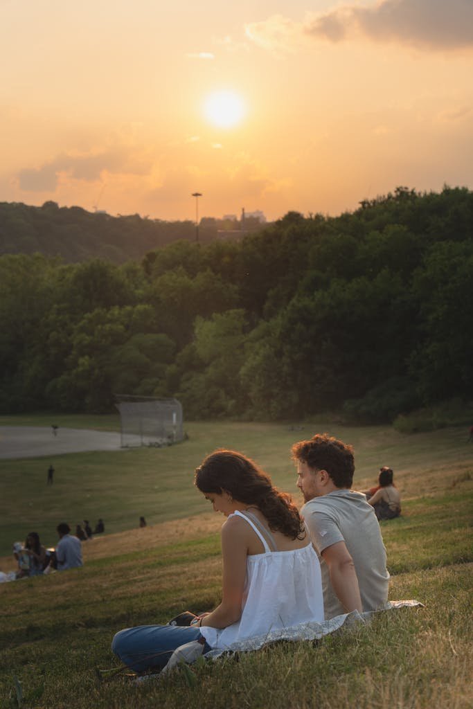 A serene moment at Riverdale Park, Toronto, as a couple enjoys a beautiful sunset together.